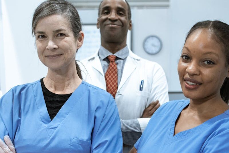 A diverse team of doctors and nurses smiling confidently in a hospital setting.